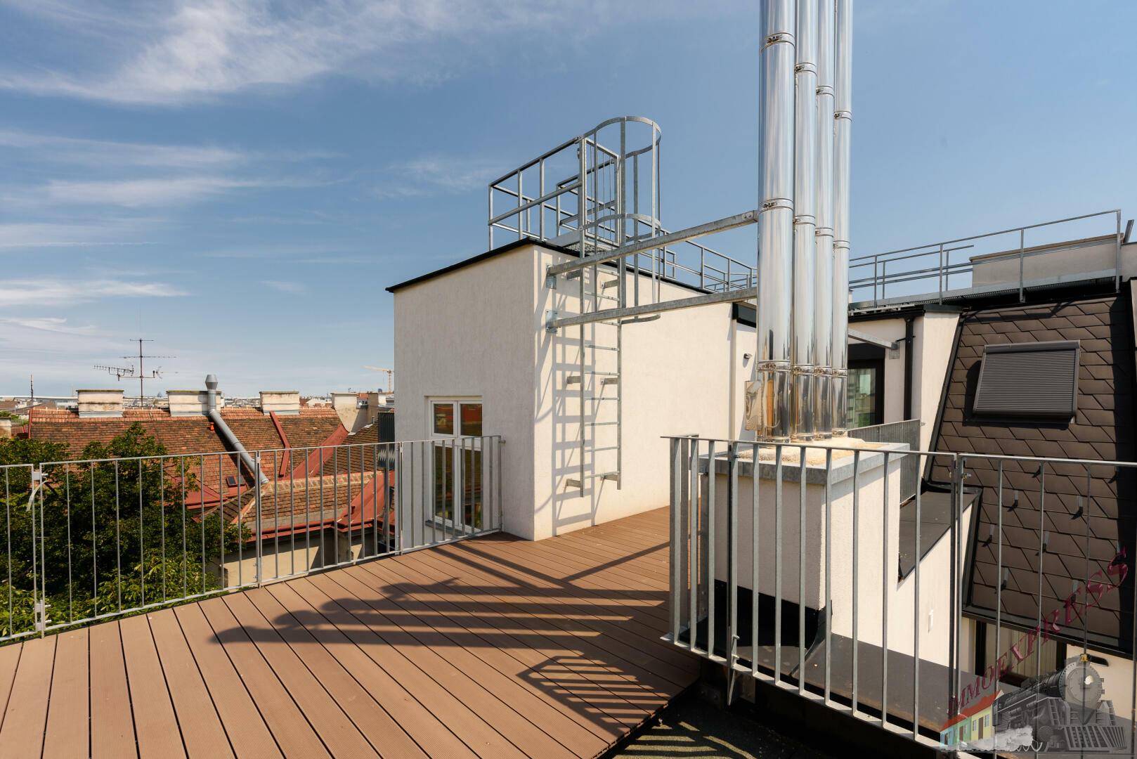 Sonnige Dachterrasse mit Holzboden und Zugang zu einem weiteren Bereich.