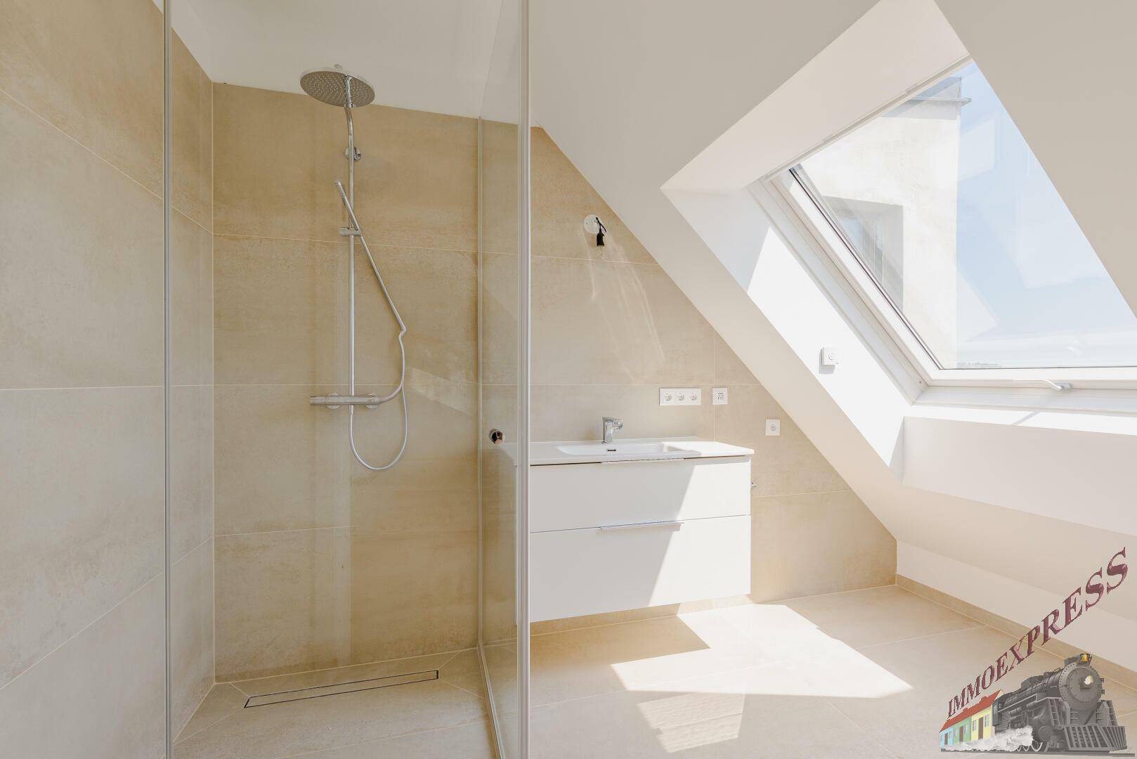 Modernes Badezimmer im Dachgeschoss mit begehbarer Dusche, Waschtisch und Dachfenster.