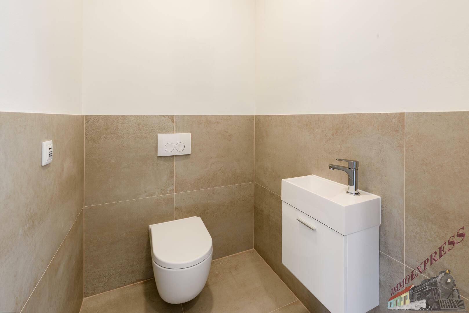 Modernes Gäste-WC mit wandhängender Toilette und kleinem Waschtisch.
