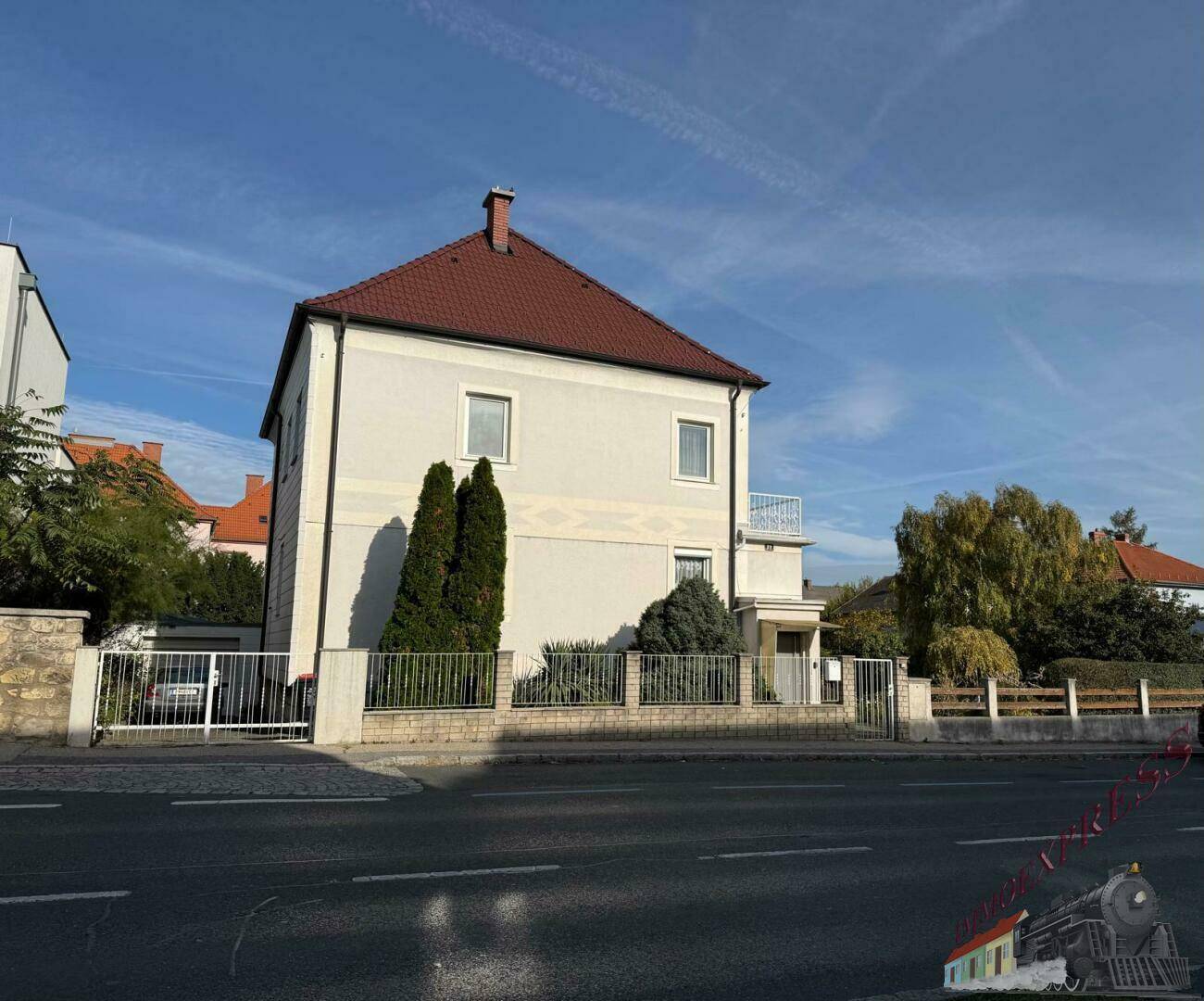 Ansicht des Wohnhauses von der Straße mit Vorgarten und Zufahrt.