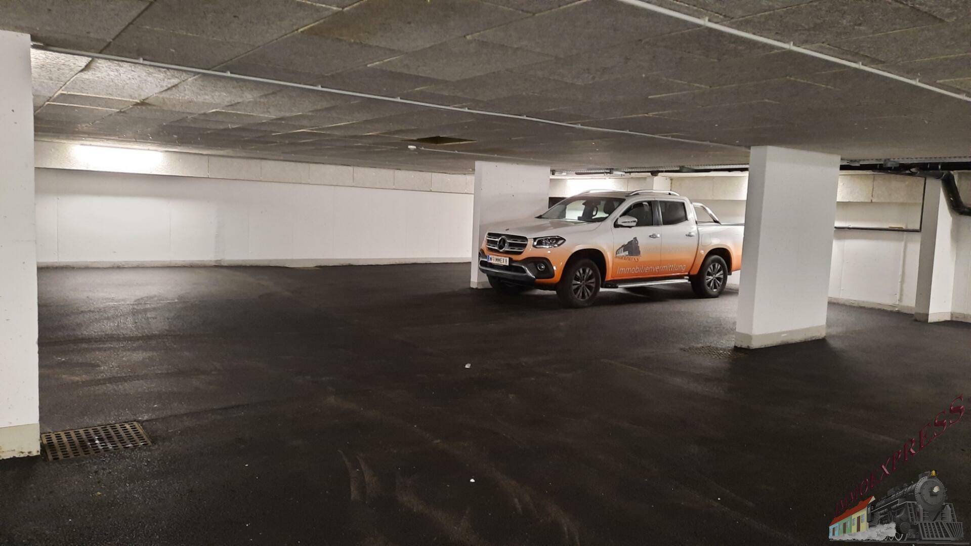 Geräumige Tiefgarage mit einem geparkten Fahrzeug und ausreichend Stellplätzen.