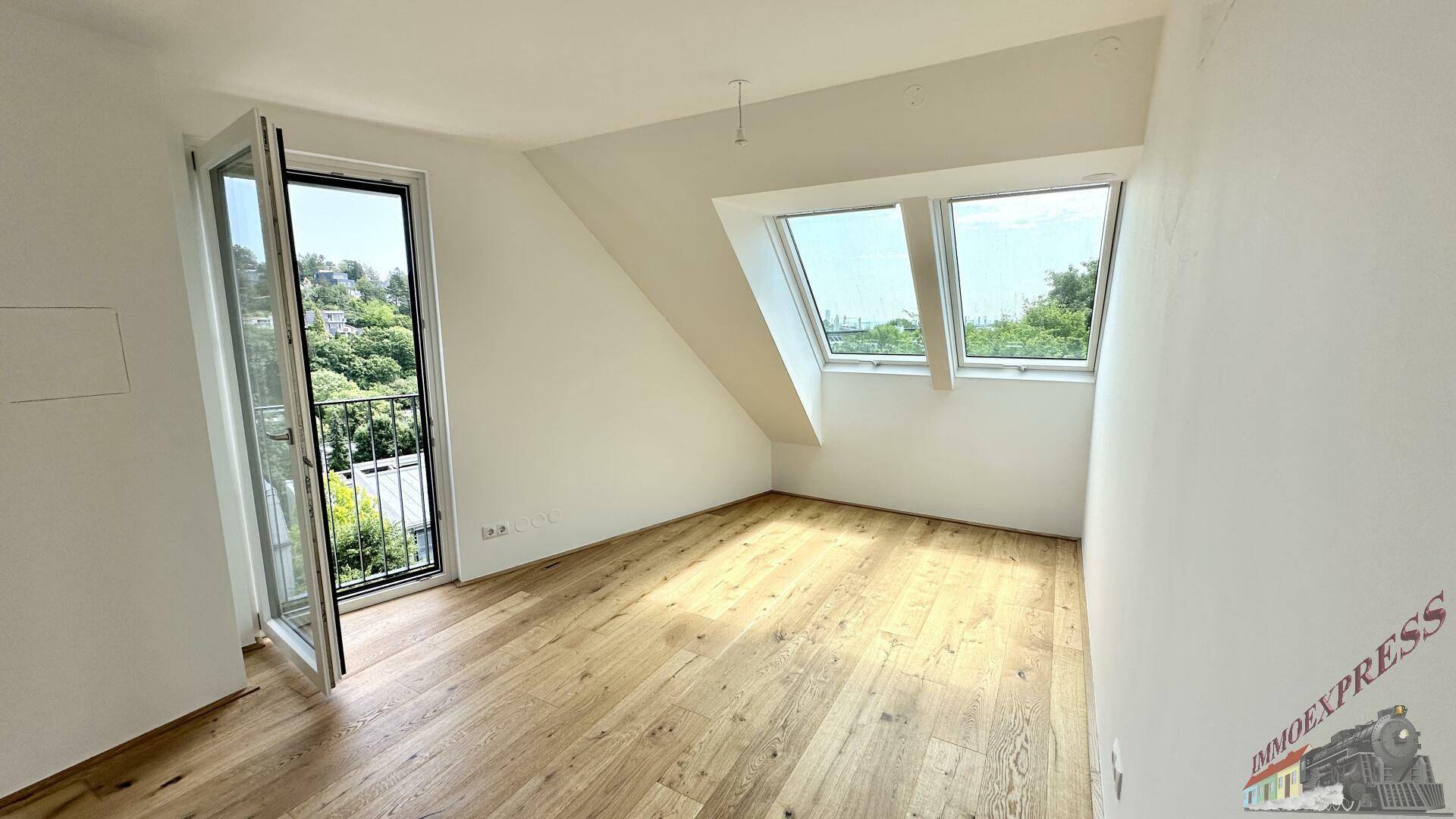 Helles Schlafzimmer mit Holzboden, französischem Balkon und Dachfenstern.