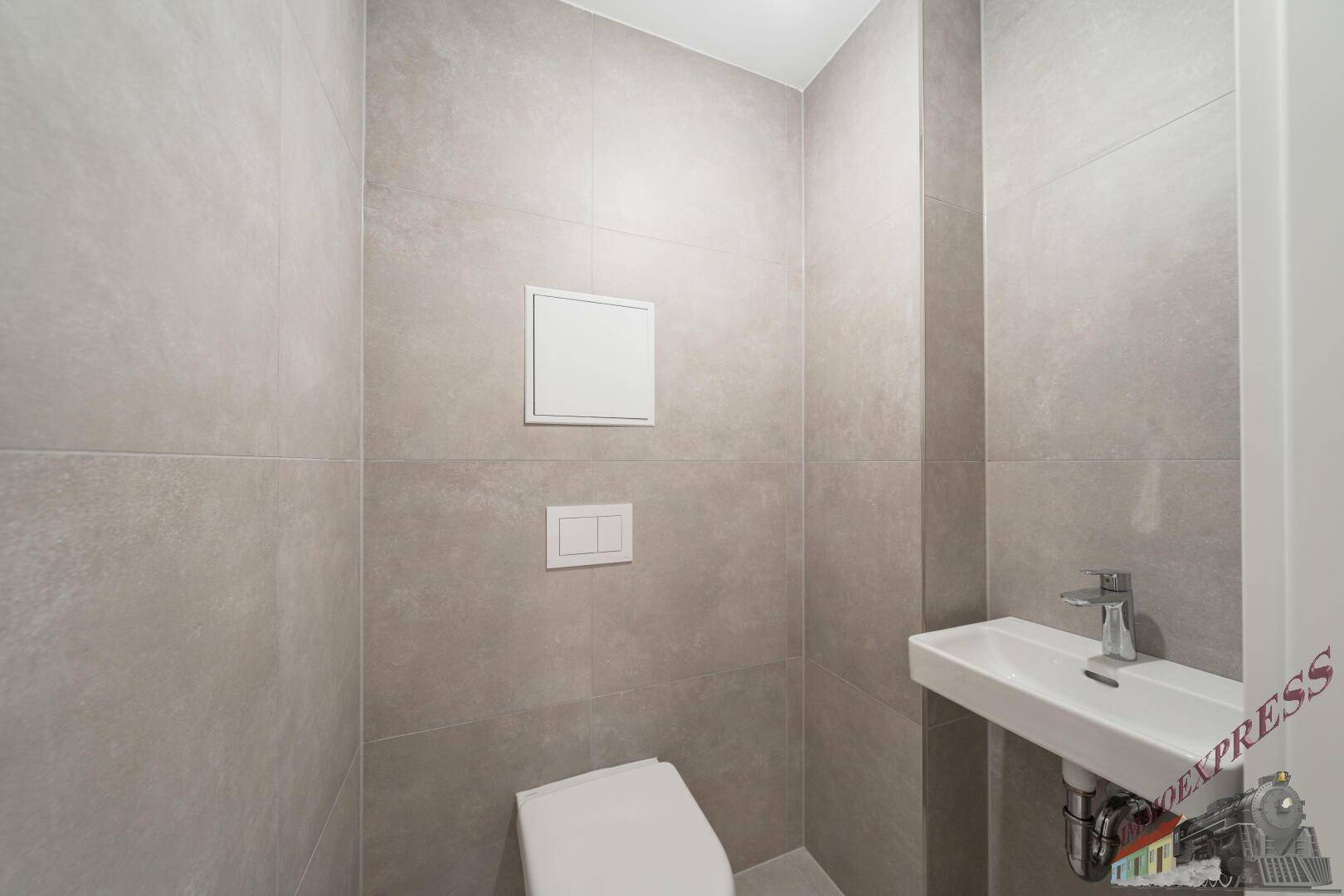 Kleines, modernes Gäste-WC mit Wand-WC, Waschbecken und grauen Fliesen.