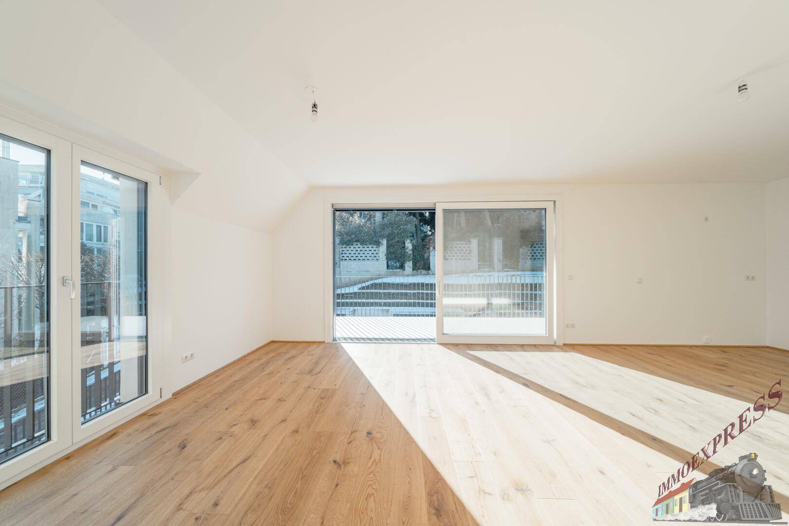 Geräumiges Wohnzimmer mit Parkettboden und Schiebetüren zum Balkon, lichtdurchflutet.
