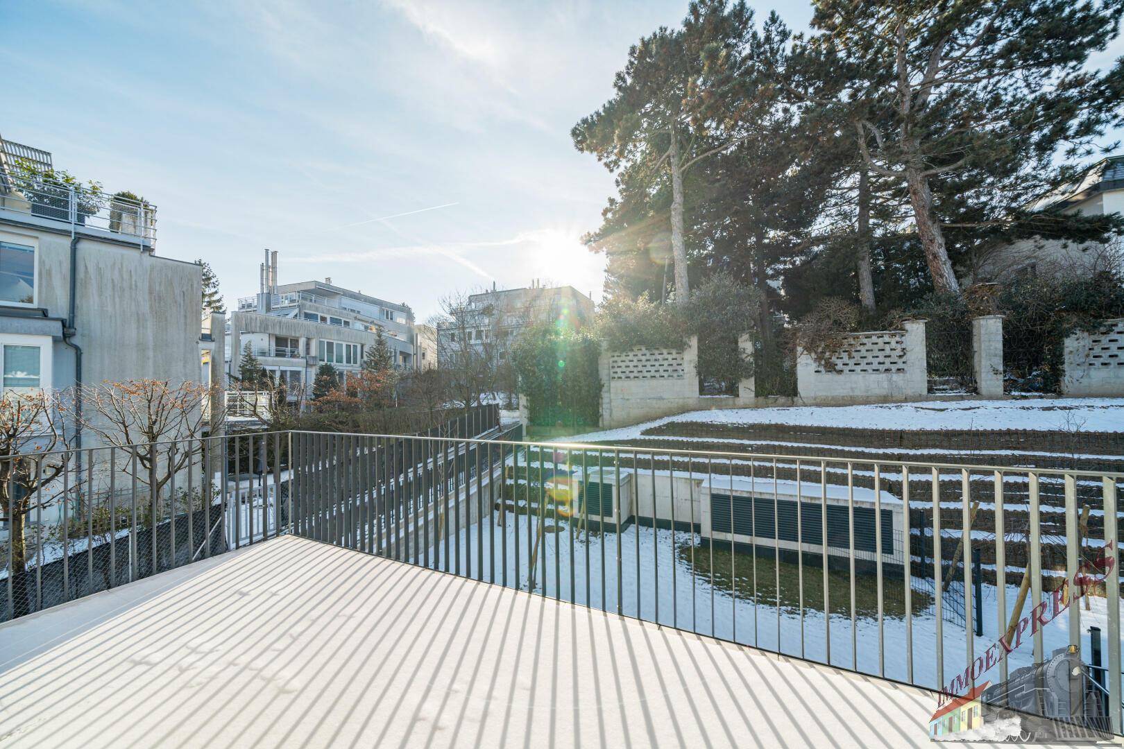 Winterliche Terrasse mit Blick auf die umliegenden Gebäude und den schneebedeckten Garten.