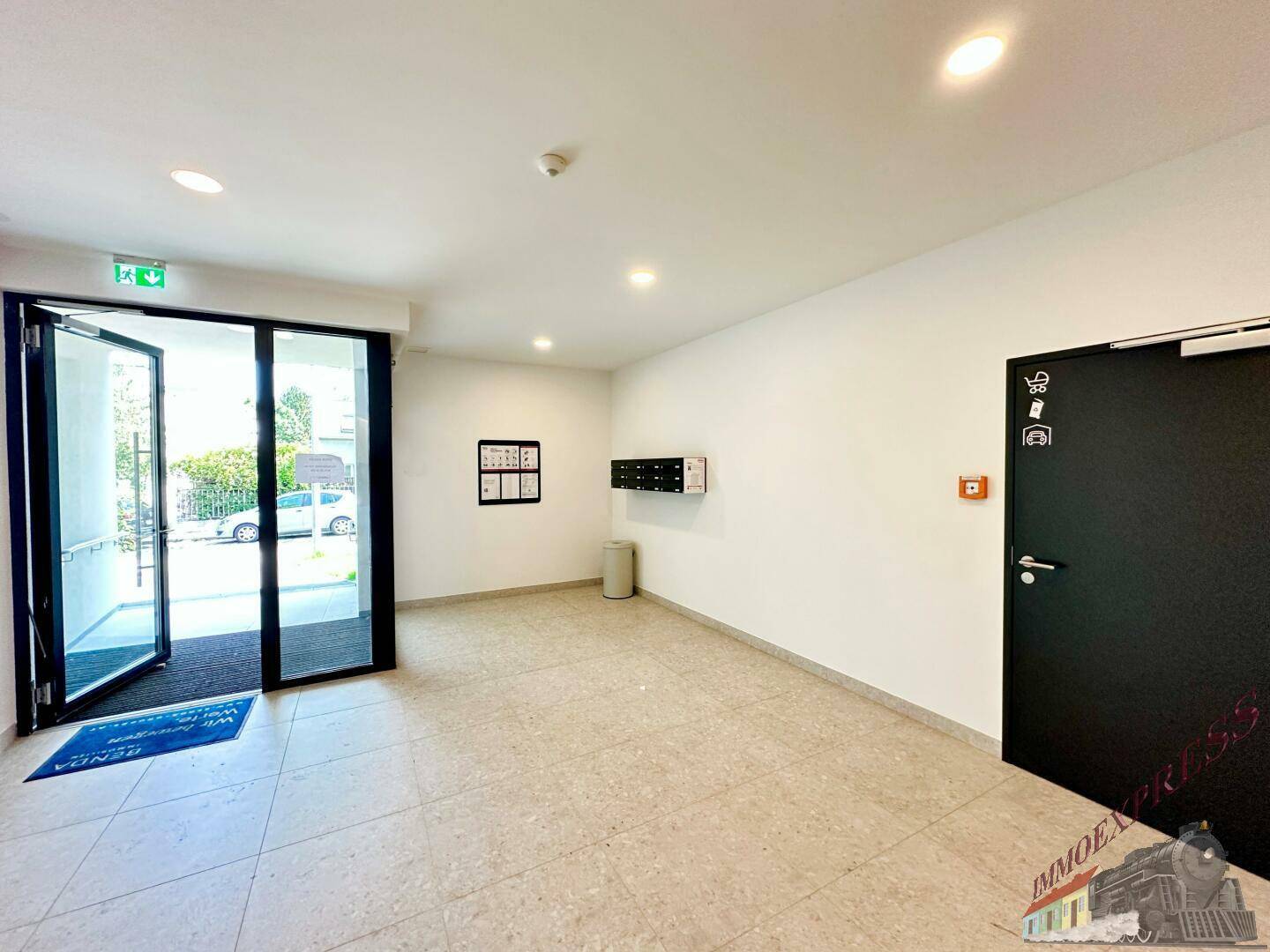 Geräumiger Eingangsbereich mit Fliesenboden und Zugang zum Treppenhaus und den Wohnungen.