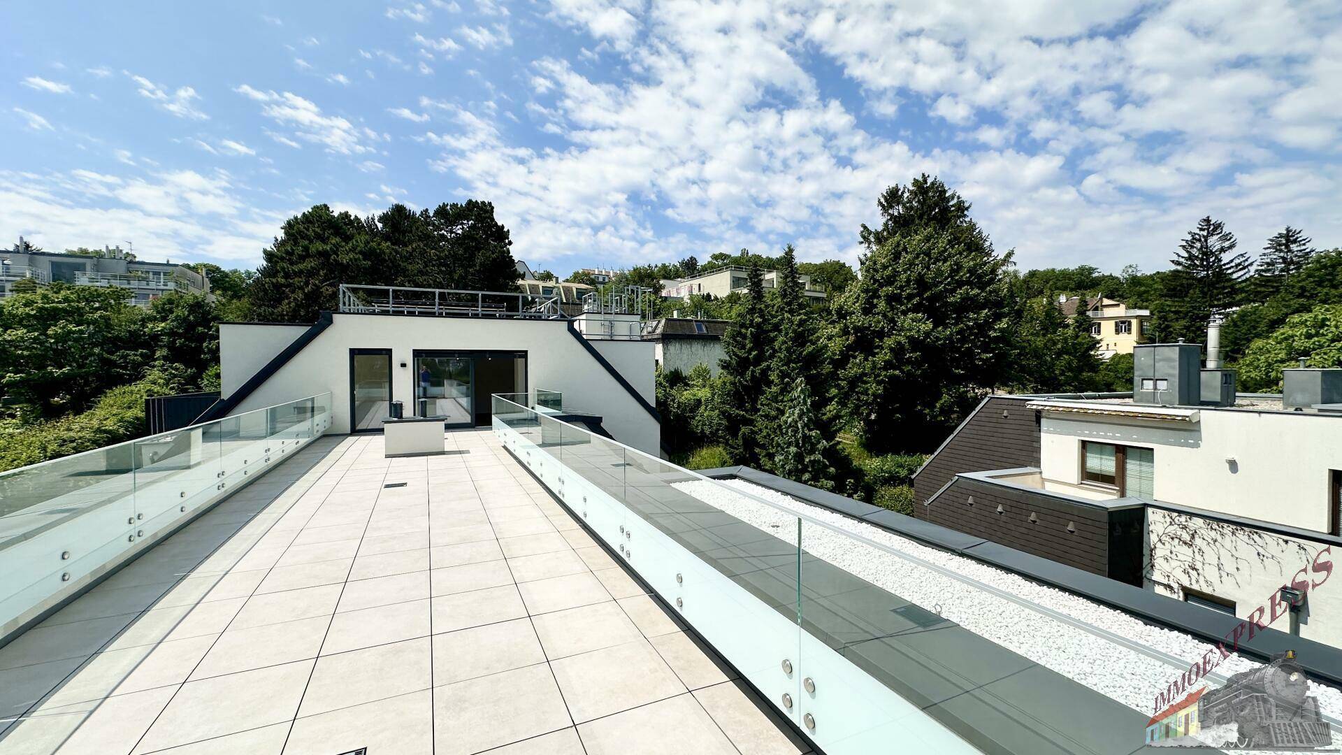 Große Dachterrasse mit moderner Architektur und weitem Blick in die grüne Umgebung.