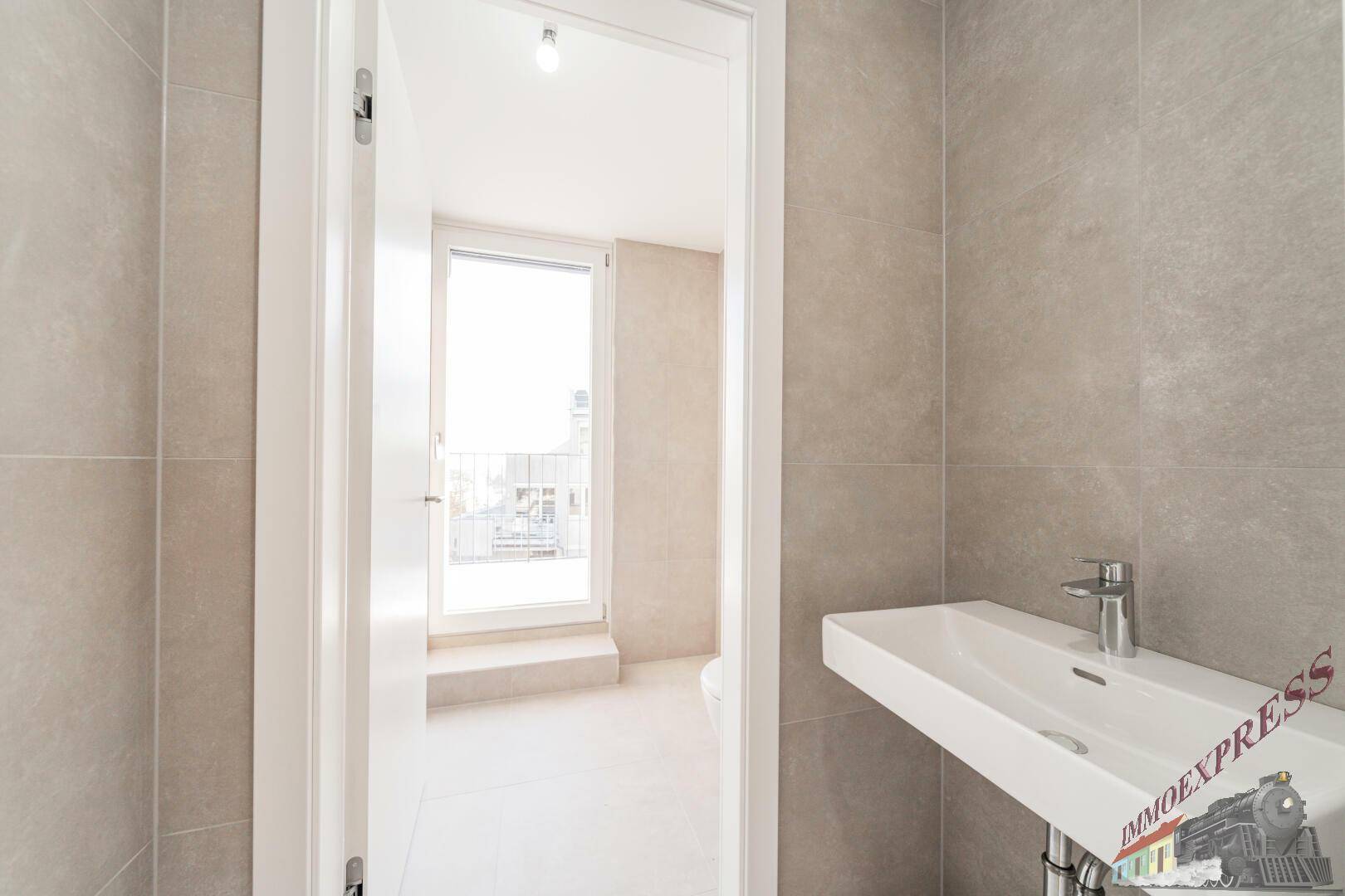 Helles Gäste-WC mit modernem Waschbecken und Zugang zu einem kleinen Außenbereich.