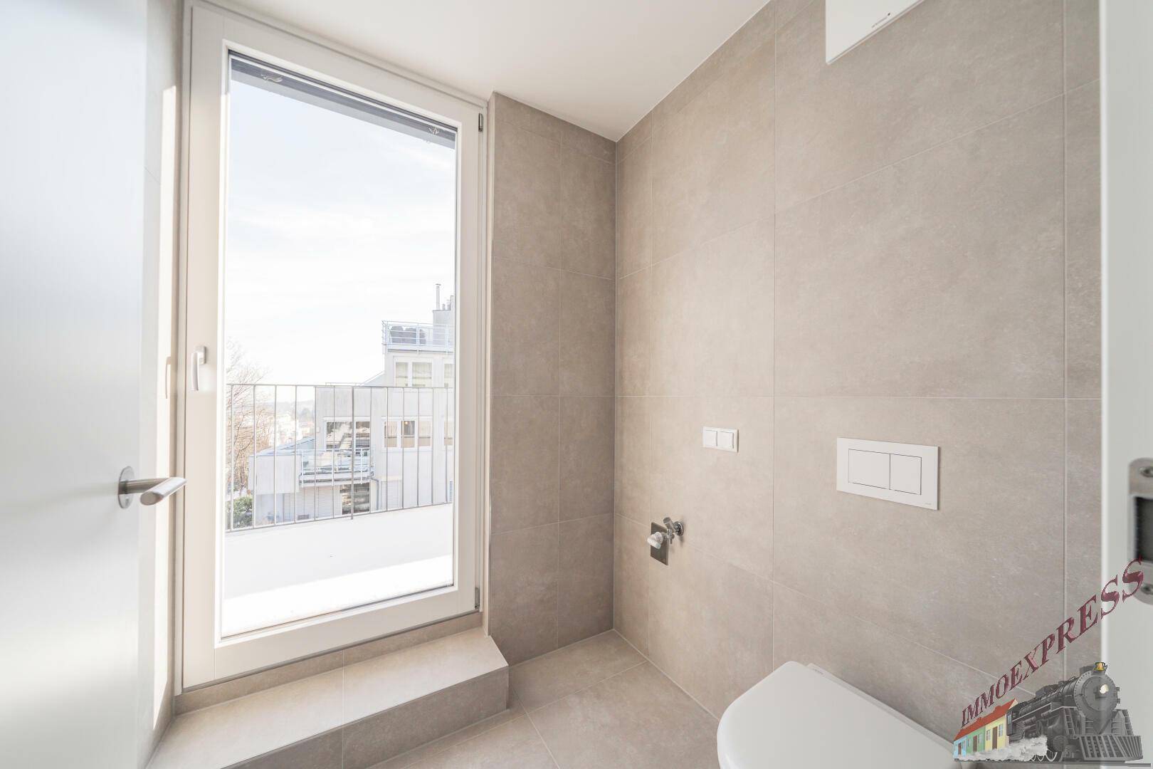 Modernes Gäste-WC mit wandmontierter Toilette und Fenster für natürliche Belüftung.