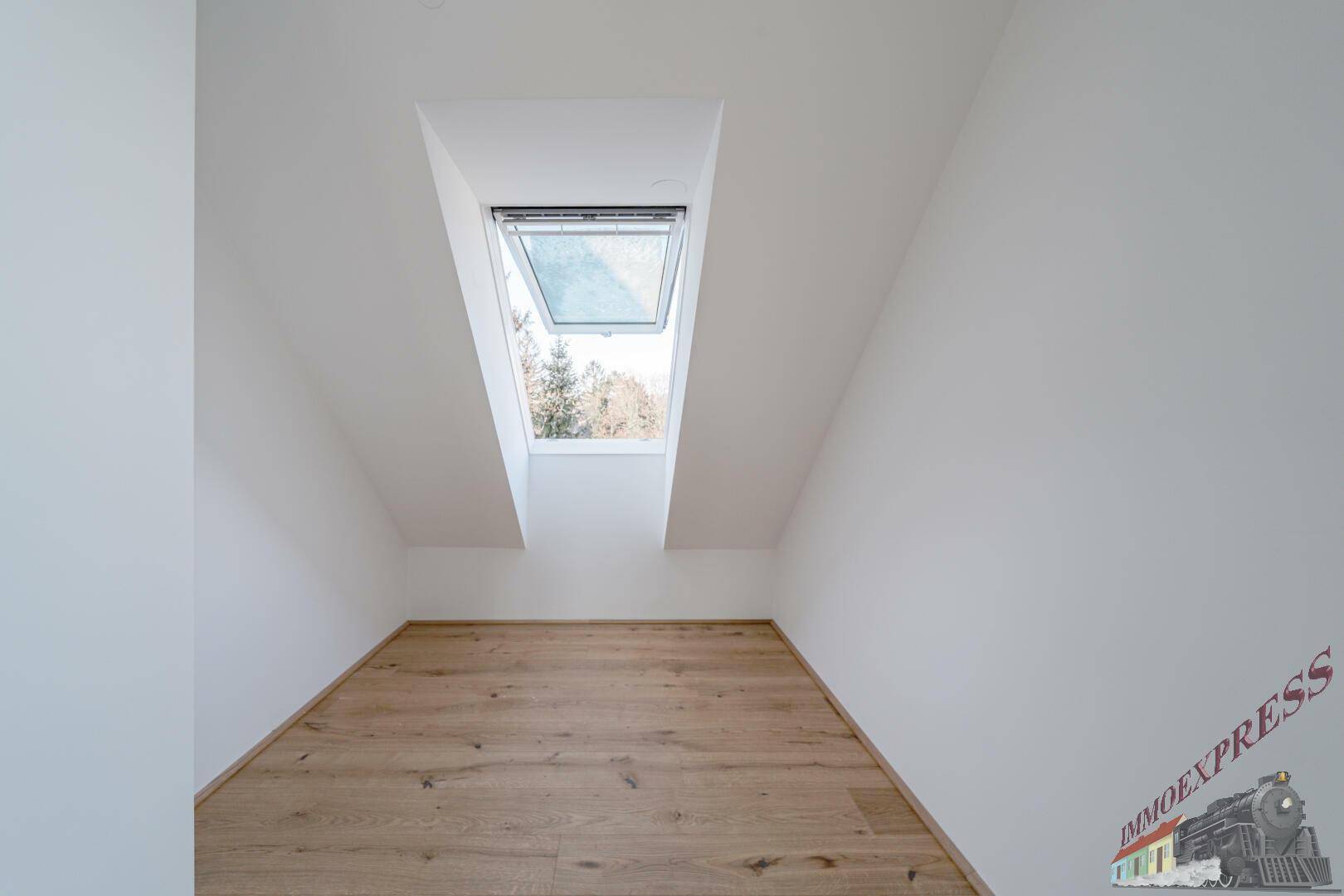 Kleiner, heller Raum mit Holzboden und Dachfenster, ideal als Abstellraum oder Büro.
