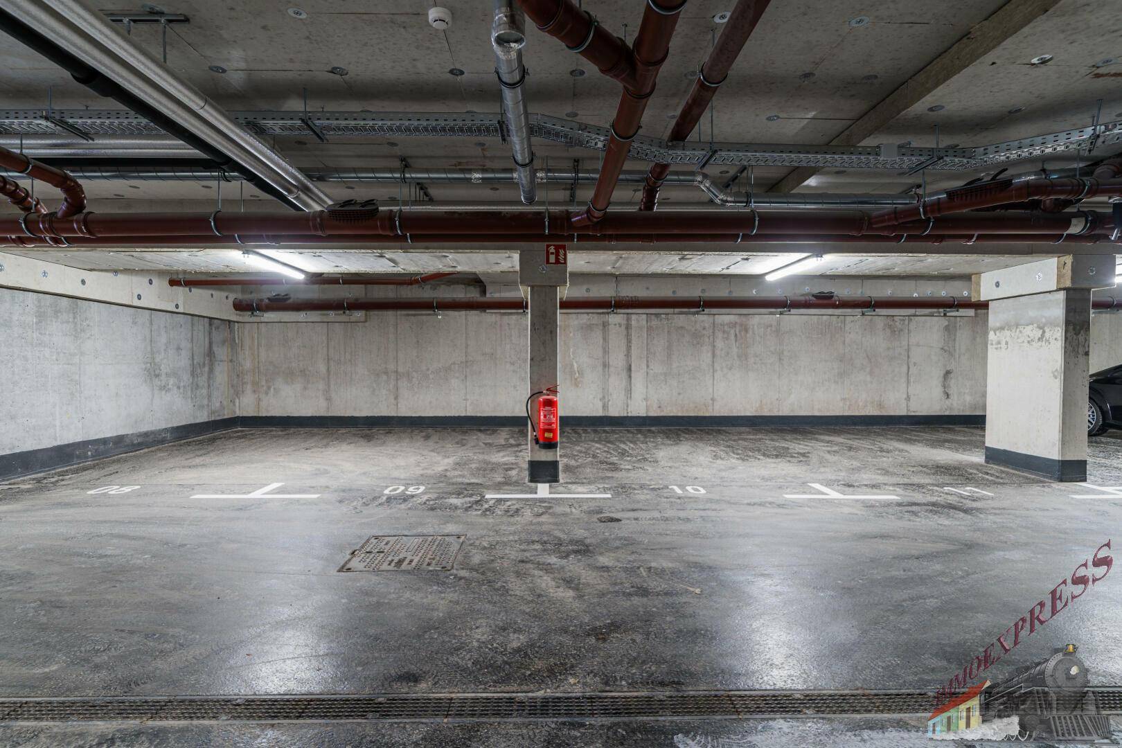 Geräumige Tiefgarage mit Betonboden und ausreichend Stellplätzen für Fahrzeuge.
