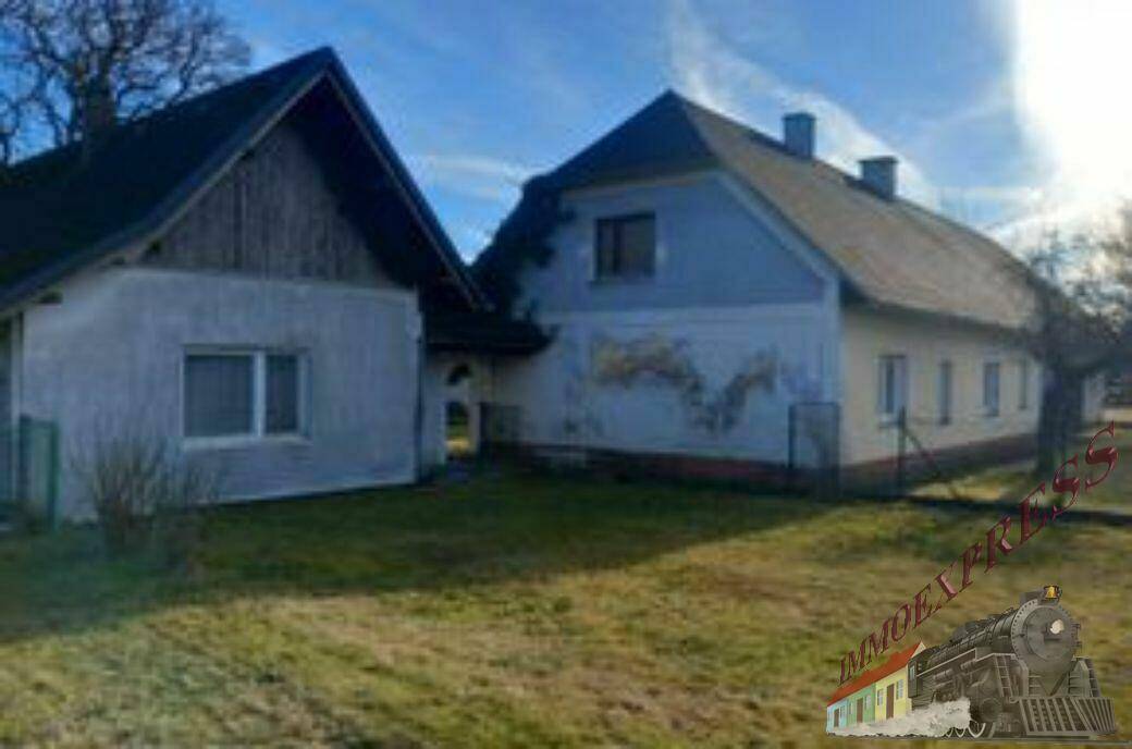 Mehrere Gebäude auf dem Grundstück mit unterschiedlichen Dachformen und Fassadenfarben, umgeben von Grünflächen.