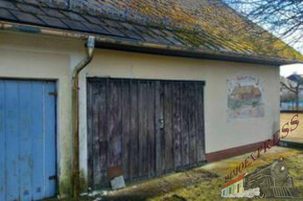 Alte Holzgaragentore und eine bemalte Wand an der Fassade des ländlichen Gebäudes.