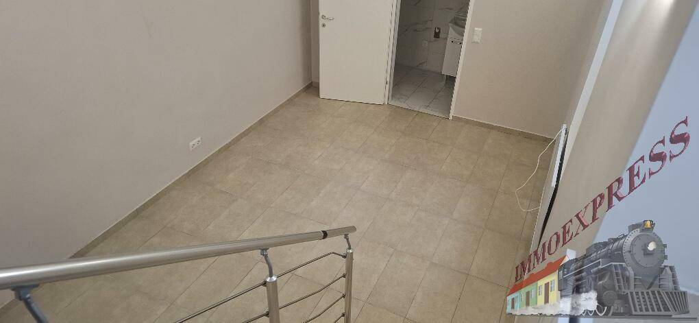 Blick vom Treppenabsatz auf den gefliesten Boden und eine geschlossene Tür zu einem angrenzenden Raum.