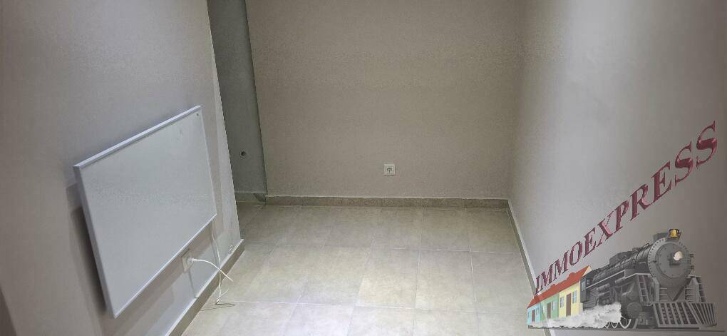 Leerer Raum mit hellem Fliesenboden und einem an der Wand montierten Heizkörper.