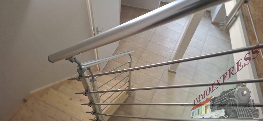 Detailansicht des modernen Treppengeländers aus Edelstahl mit horizontalen Stäben.