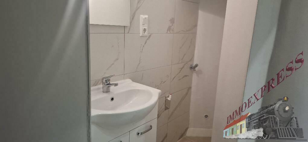 Helles Badezimmer mit modernem Waschbecken, Spiegel und eleganten weiß-marmorierten Wandfliesen.