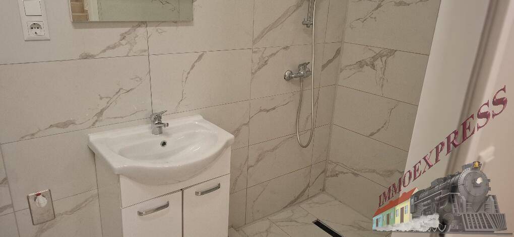 Modernes Badezimmer mit weiß-marmorierten Fliesen, einem Waschbecken und einer Duschkabine.