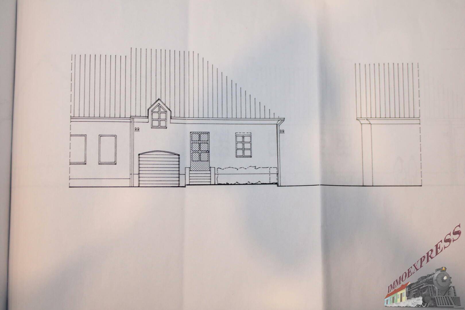 Vorderansicht des Gebäudes mit Garage und Eingangsbereich.