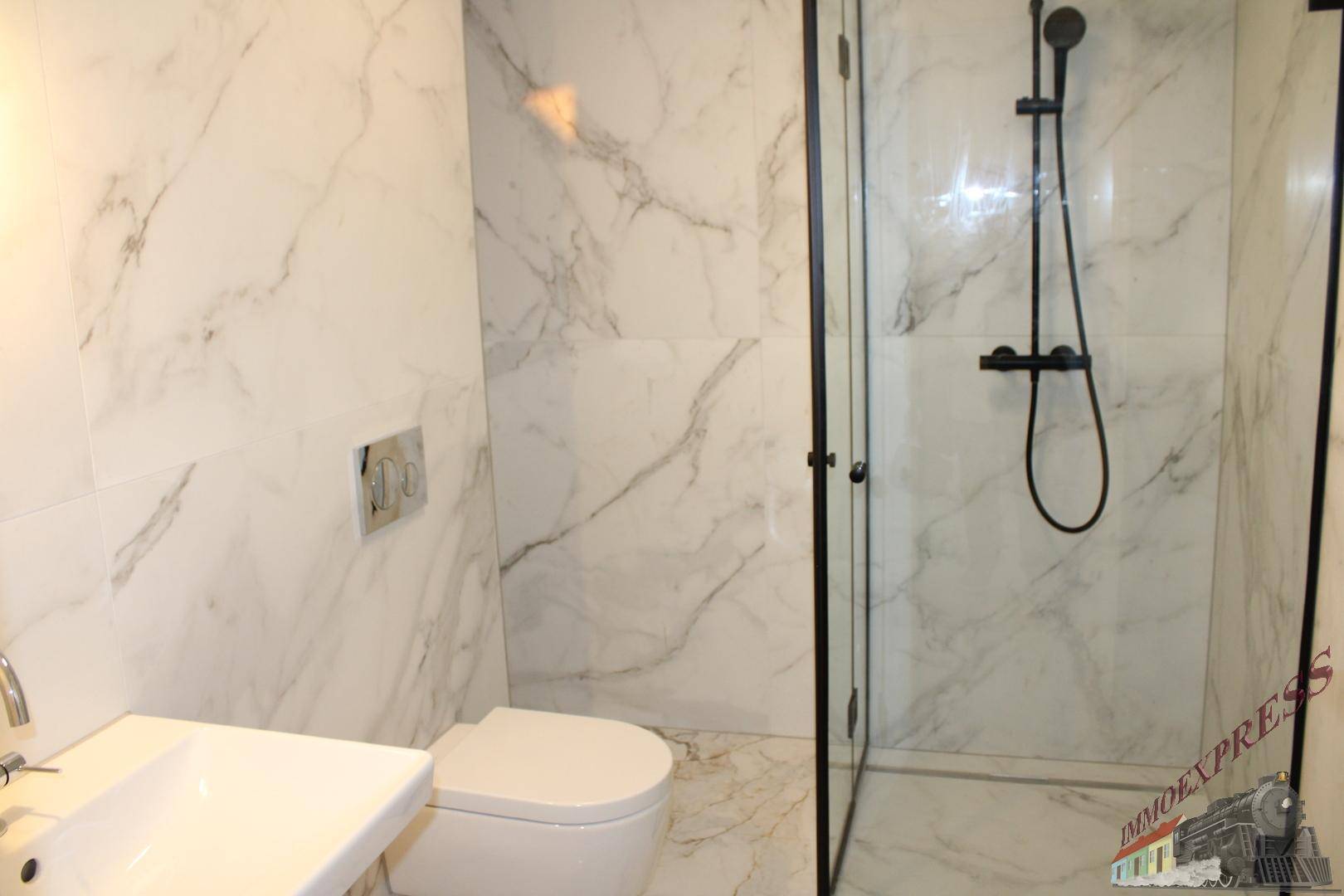 Modernes Badezimmer mit begehbarer Dusche, wandhängendem WC und eleganten Marmorfliesen.