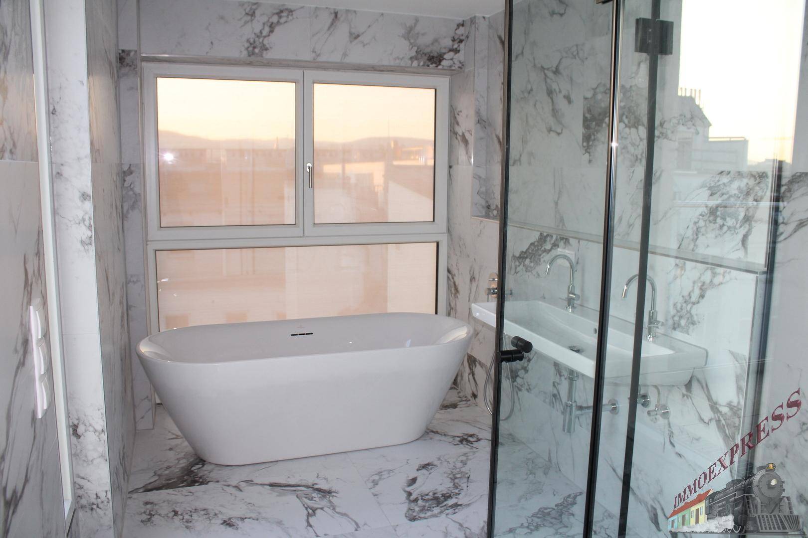 Luxuriöses Badezimmer mit freistehender Badewanne, großer Dusche und Marmorfliesen.