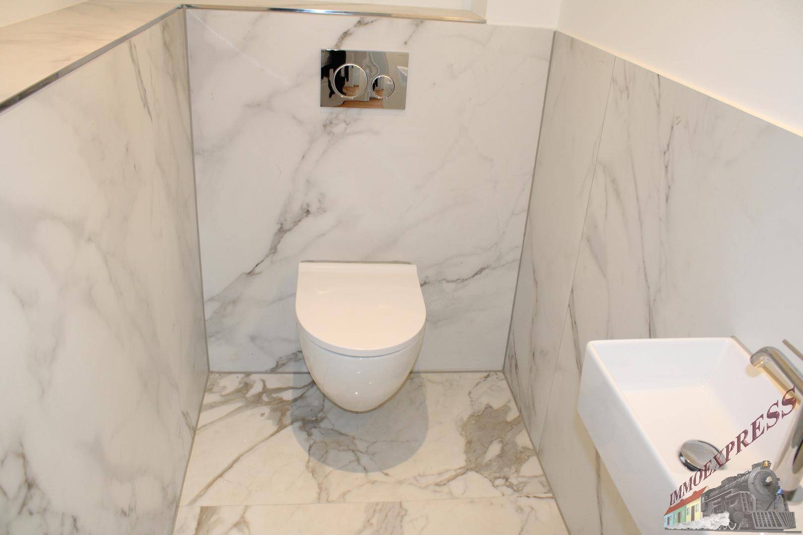 Modernes Gäste-WC mit wandhängender Toilette, kleinem Waschbecken und Marmorfliesen.