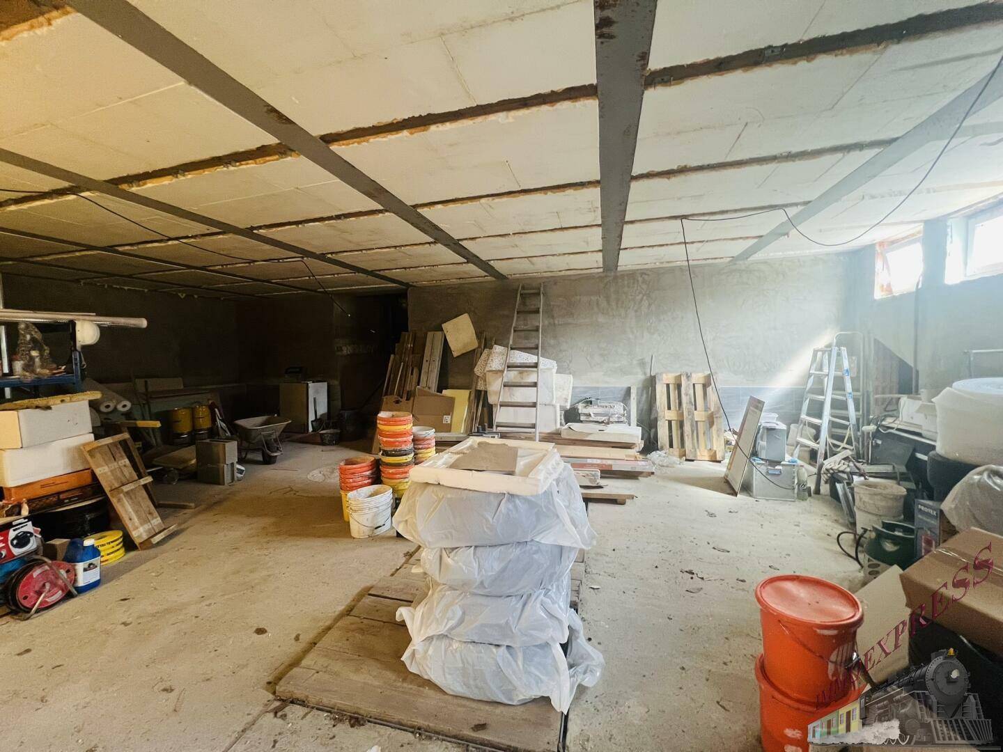 Geräumiger Lagerraum oder Kellerbereich mit Baumaterialien und Werkzeugen.