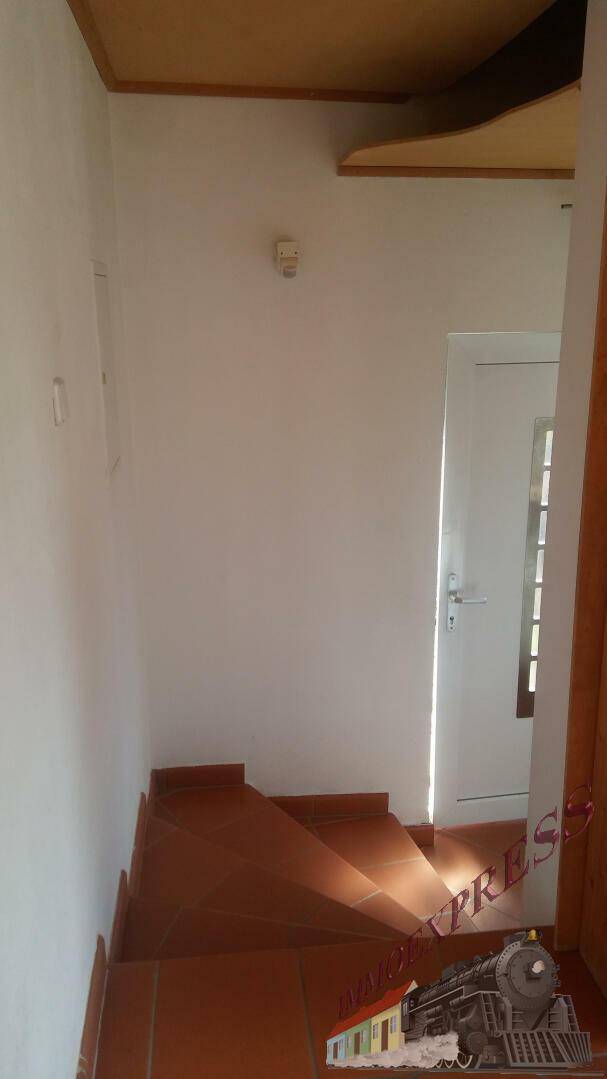 Heller Treppenaufgang mit Terrakottafliesen und weiß gestrichenen Wänden, der in die obere Etage führt.