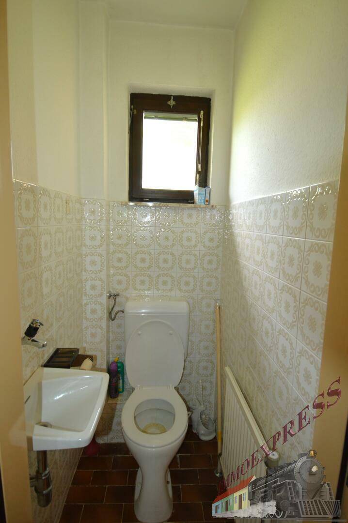 Kleines Gäste-WC mit WC, Waschbecken und Fenster für natürliche Belüftung.