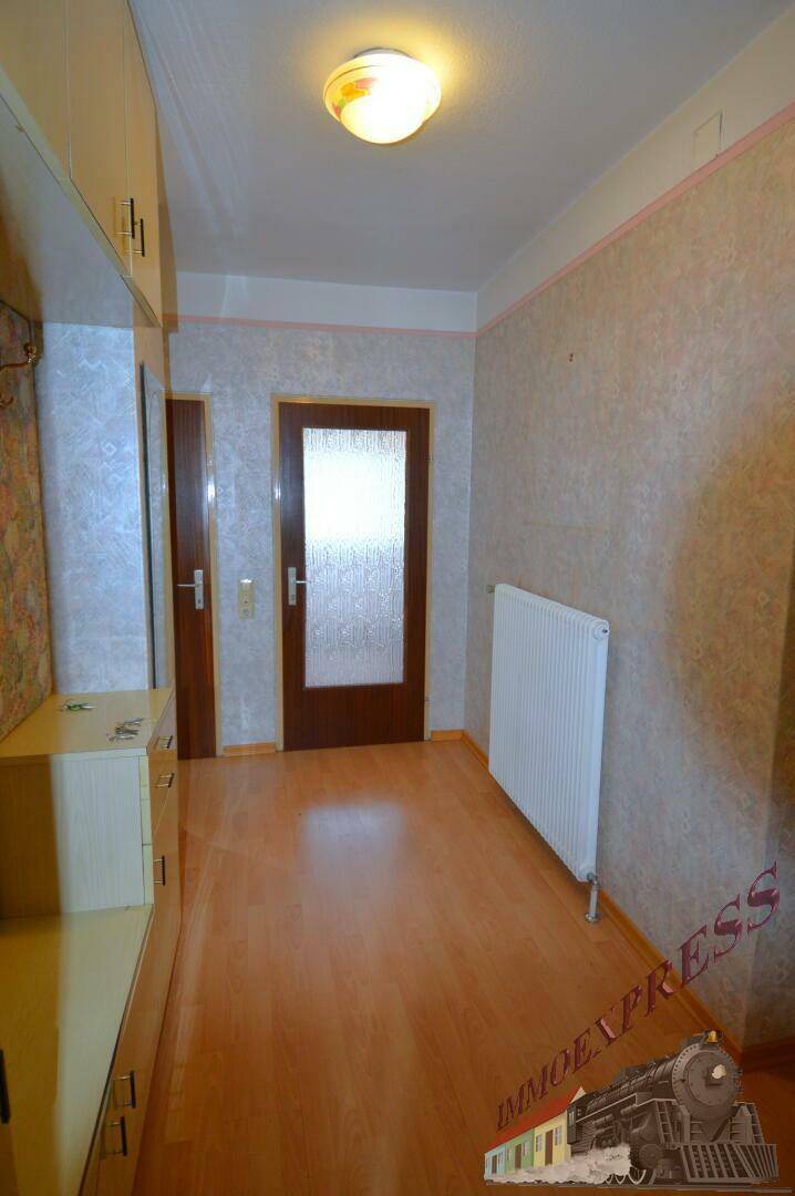 Heller Flur mit Laminatboden und Zugang zu weiteren Räumen im Haus.