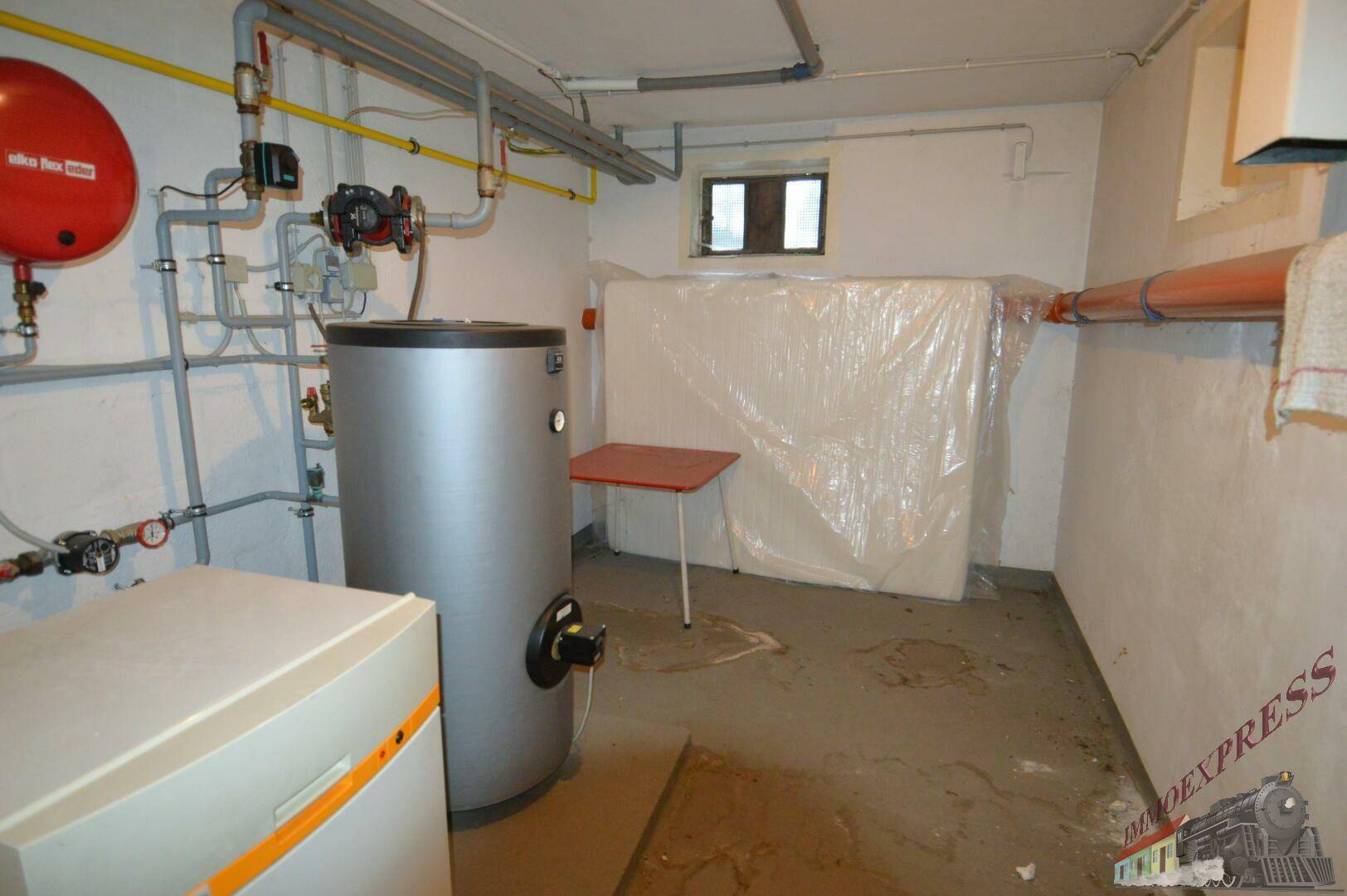 Heizungsraum im Keller mit Warmwasserspeicher und Heizungsanlage.