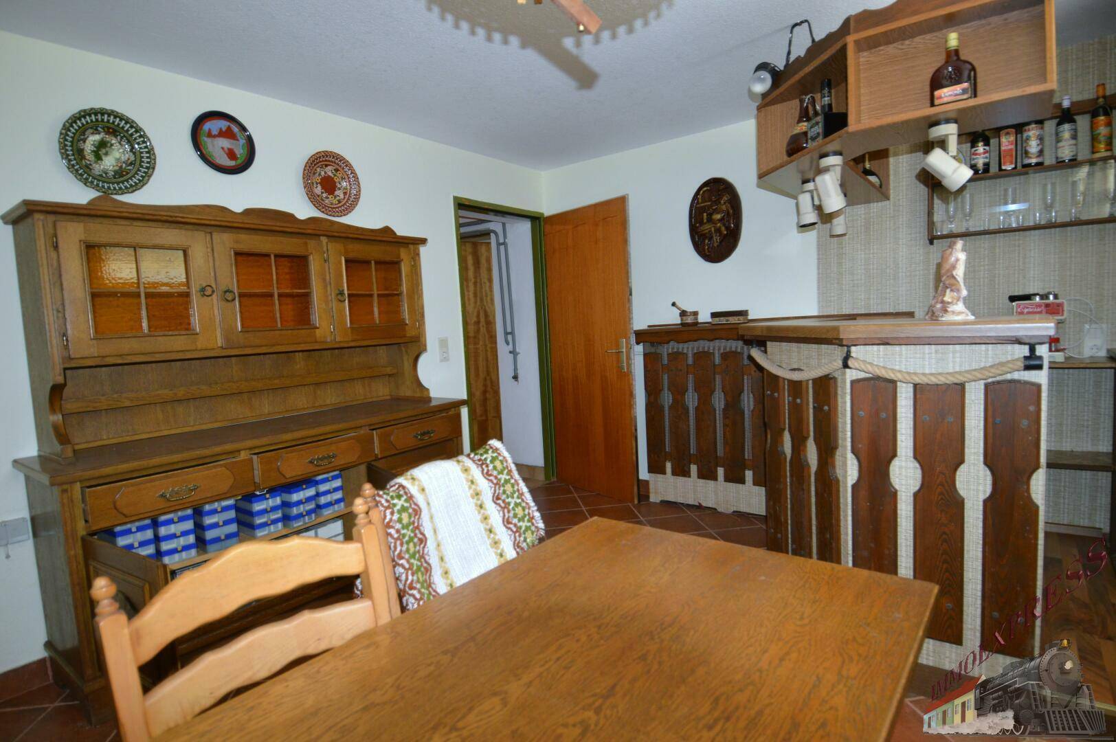 Rustikaler Hobbyraum im Keller mit Bar, Holzmöbeln und Dekoration.