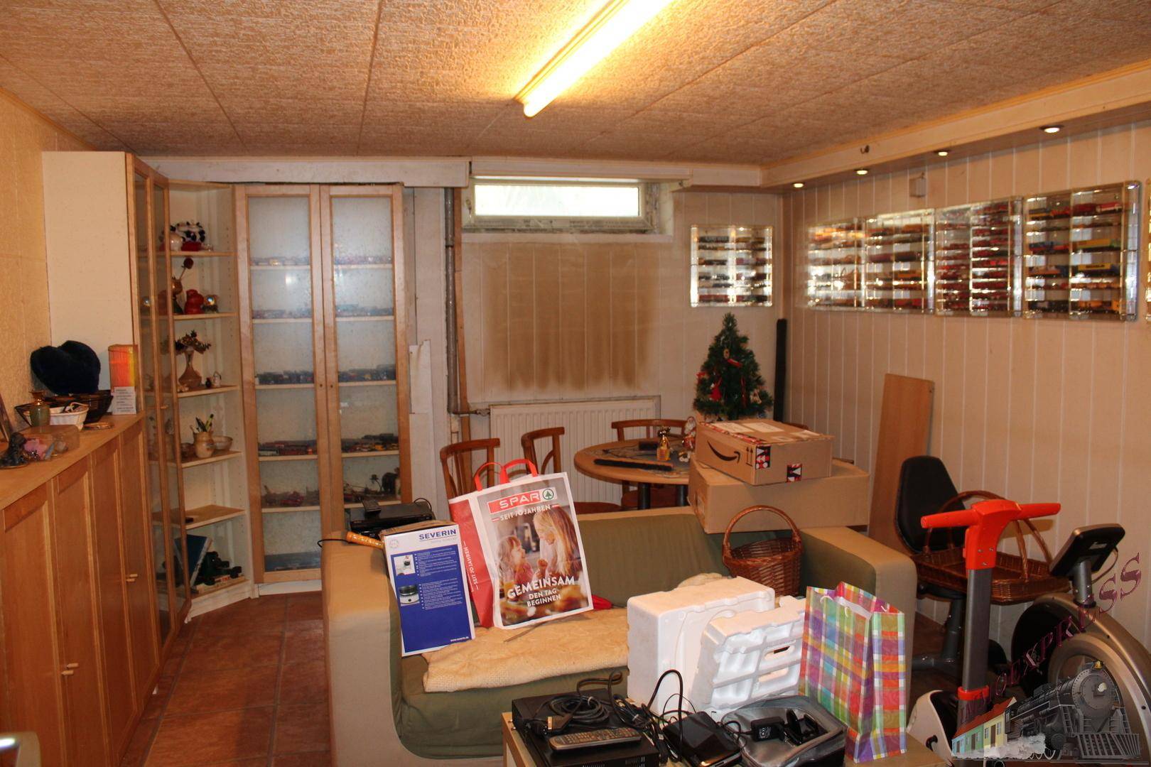 Kellerraum mit Regalen, Möbeln und einem kleinen Fenster, genutzt als Hobbyraum.