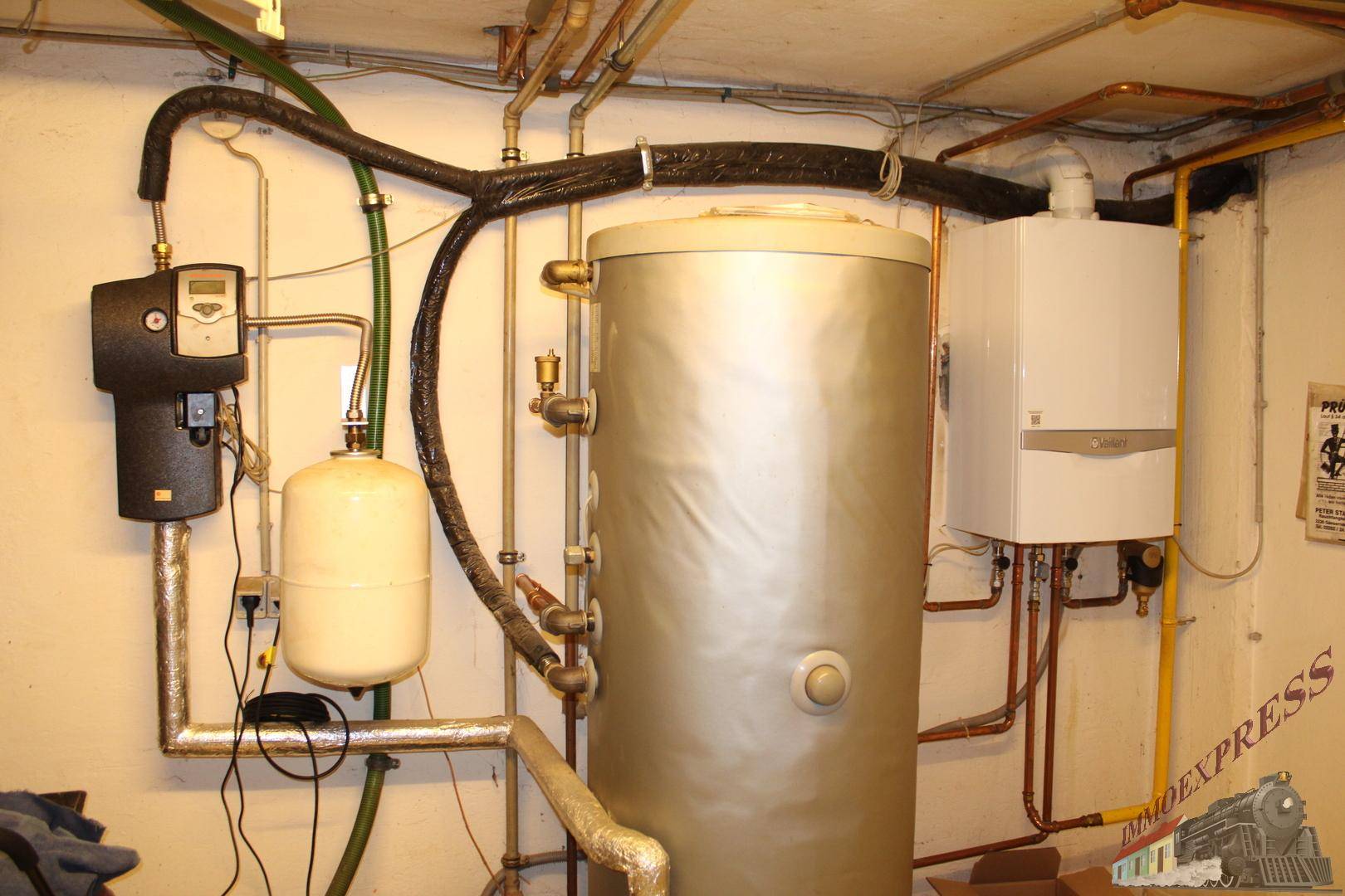 Heizungsraum im Keller mit Warmwasserspeicher und Gastherme.