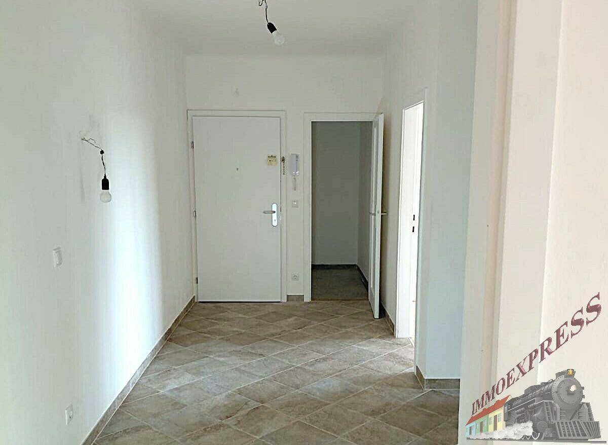 Heller Eingangsbereich mit gefliestem Boden und Zugang zu weiteren Räumen der Wohnung.