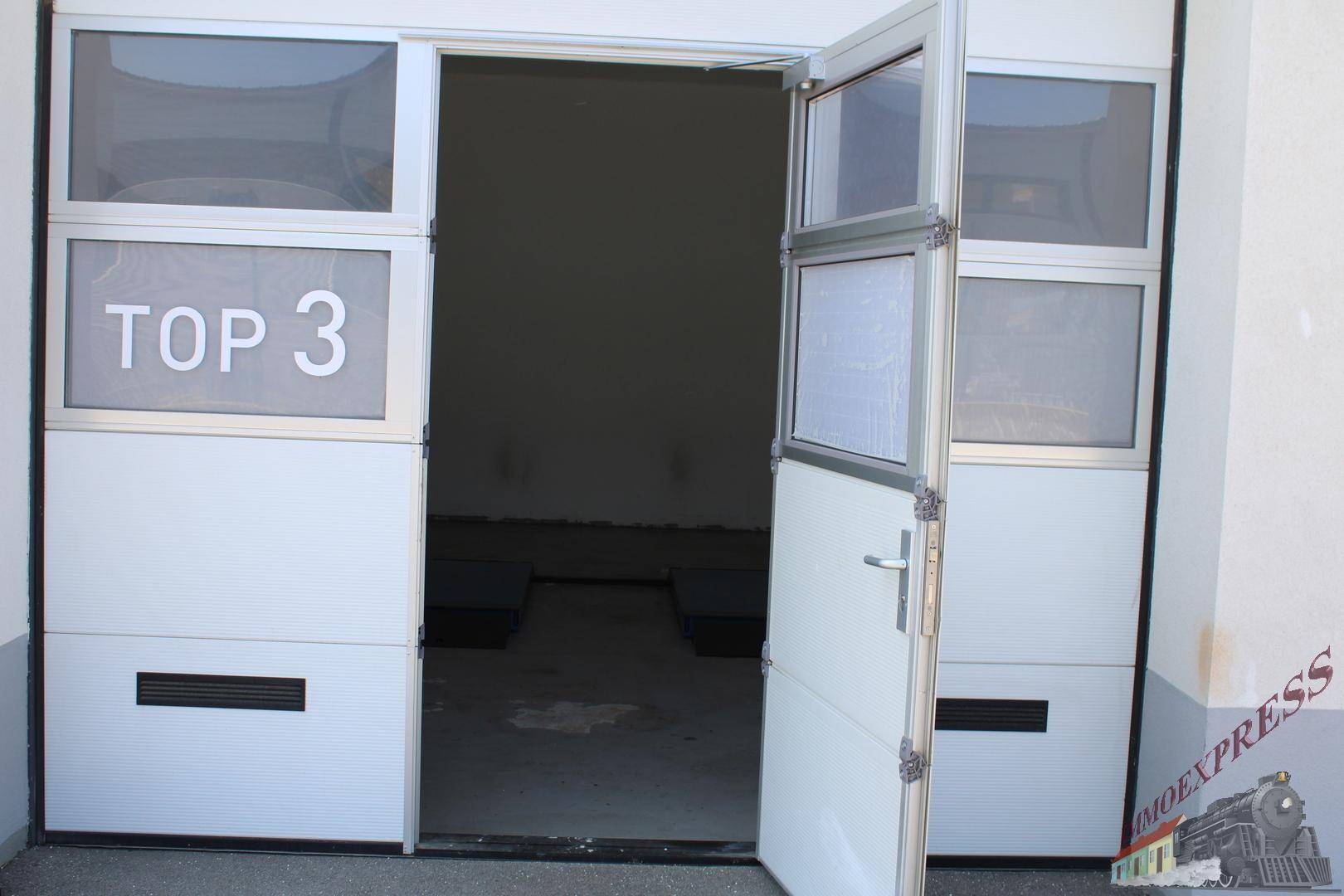 Innenansicht einer Garagenbox mit geöffnetem Tor und Betonboden, bereit zur Nutzung.