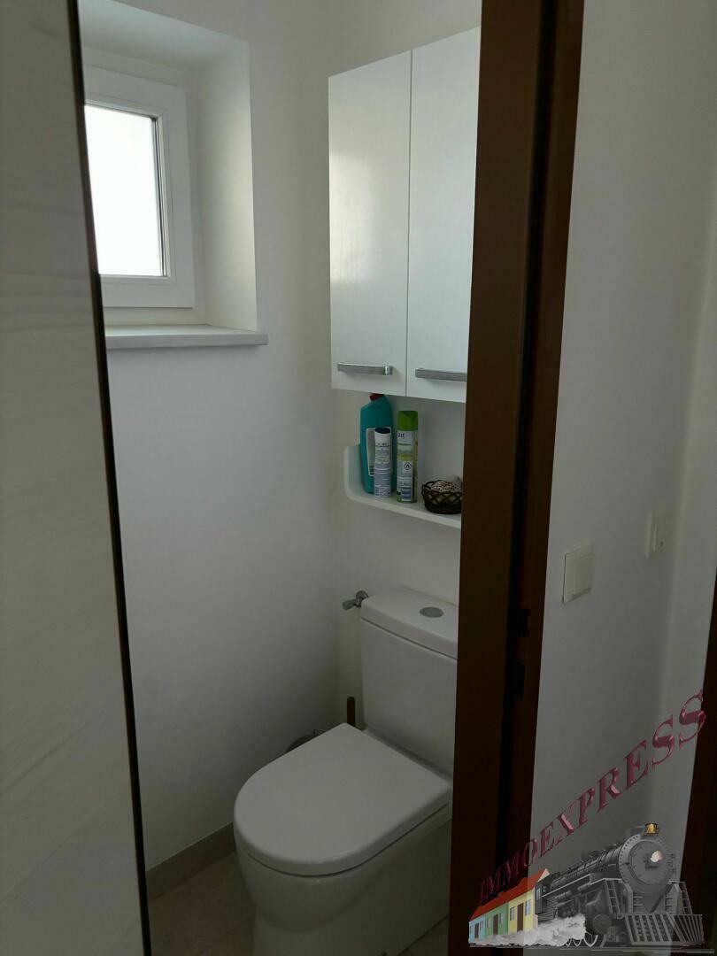 Kleines Gäste-WC mit Toilette und einem Fenster für natürliche Belüftung.