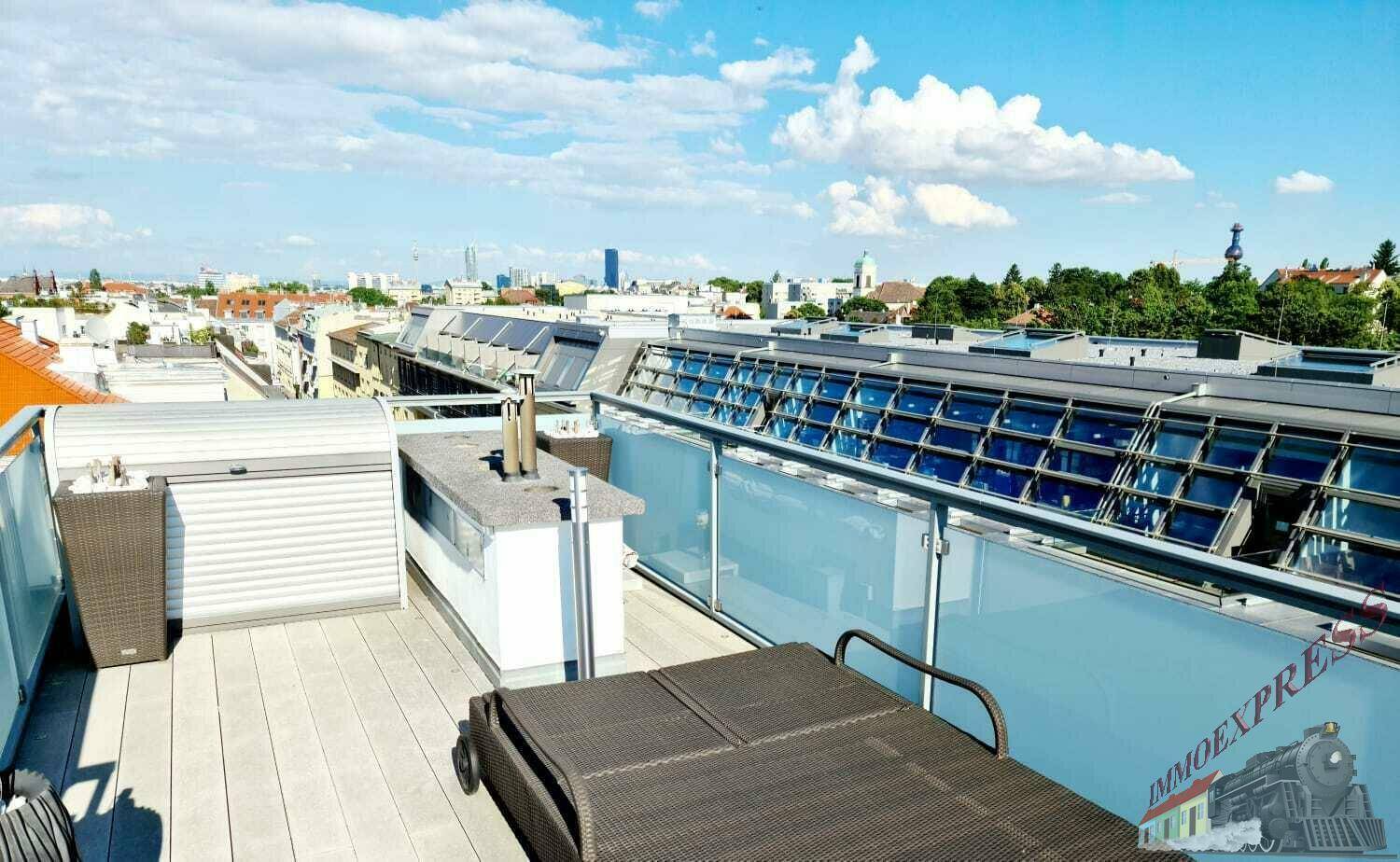 Weitläufige Dachterrasse mit Liegeflächen und einer kleinen Außenküche, bietet einen Panoramablick auf die Stadt.