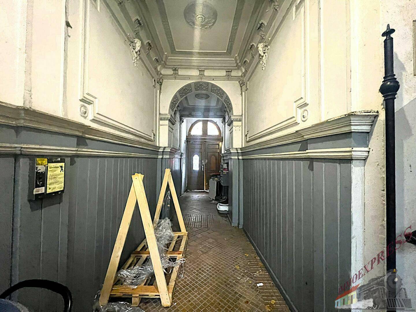 Historischer Flur mit gewölbter Decke, Stuckelementen und Baustellenzubehör im Eingangsbereich.