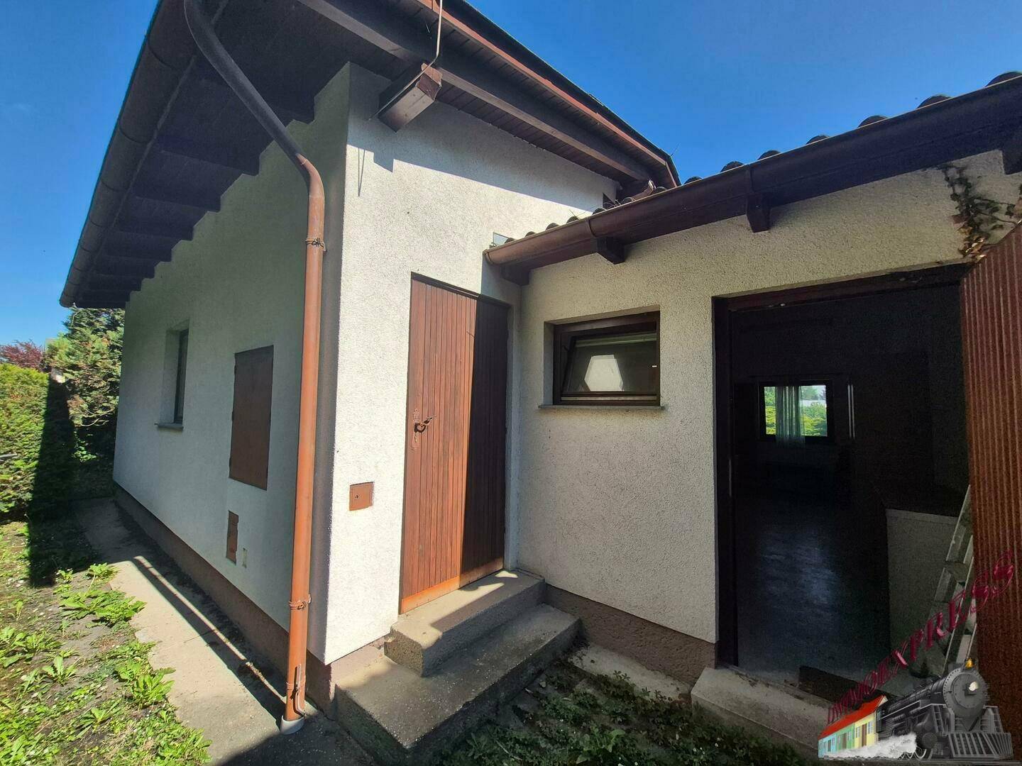 Rückseite des Hauses mit Eingangstür und Zugang zum Garten.