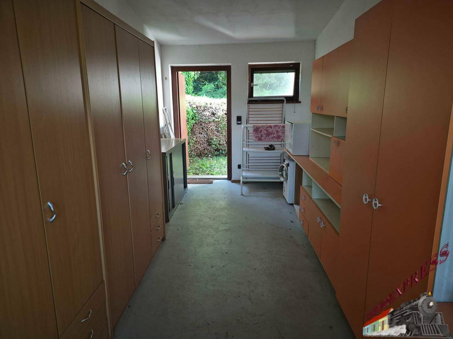 Hauswirtschaftsraum mit Schränken, Zugang zum Garten und Tageslicht.