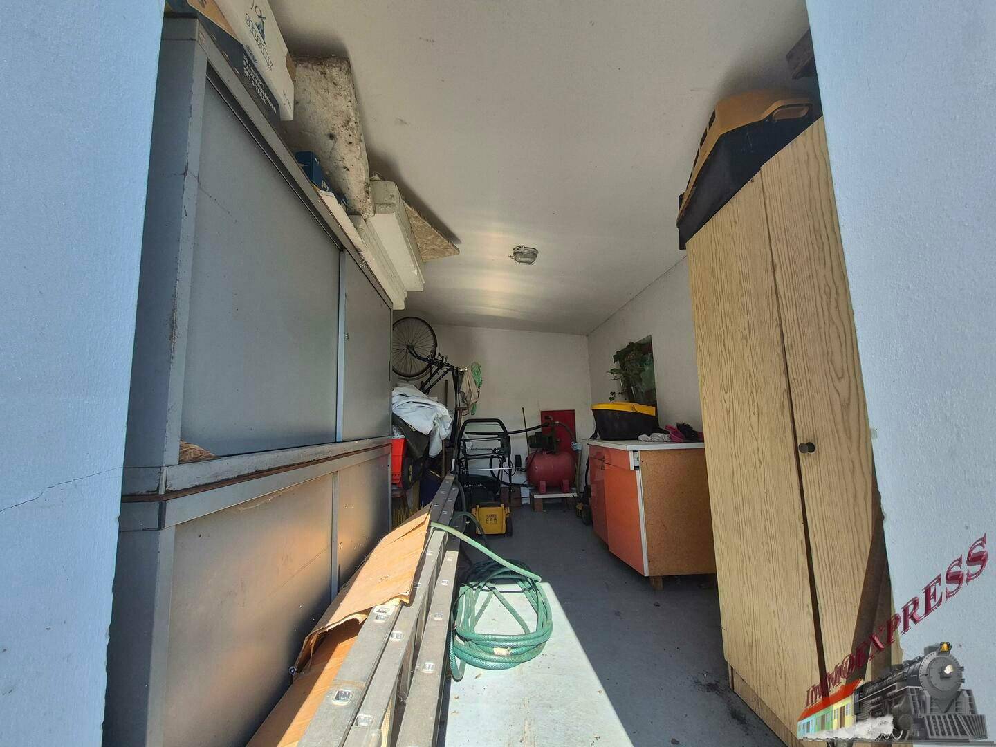 Geräumiger Abstellraum mit Regalen, Werkzeugen und Fahrrädern.
