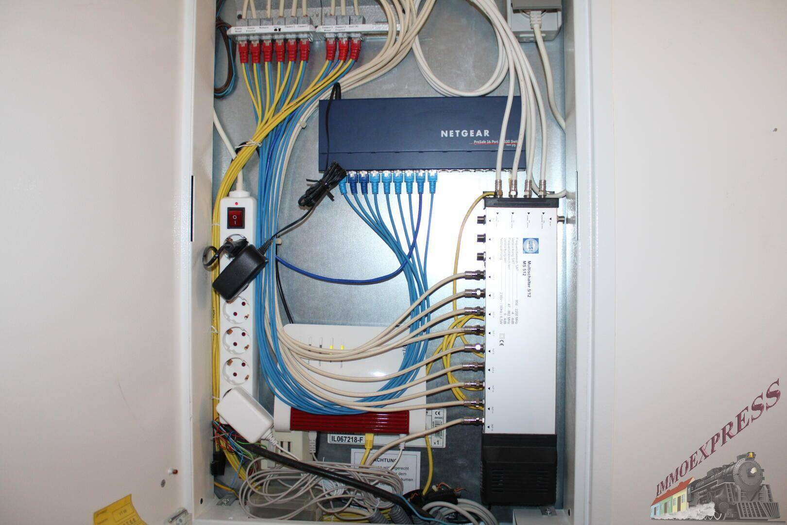 Übersichtlicher Netzwerkschrank mit Router und Verkabelung für die Hauskommunikation.