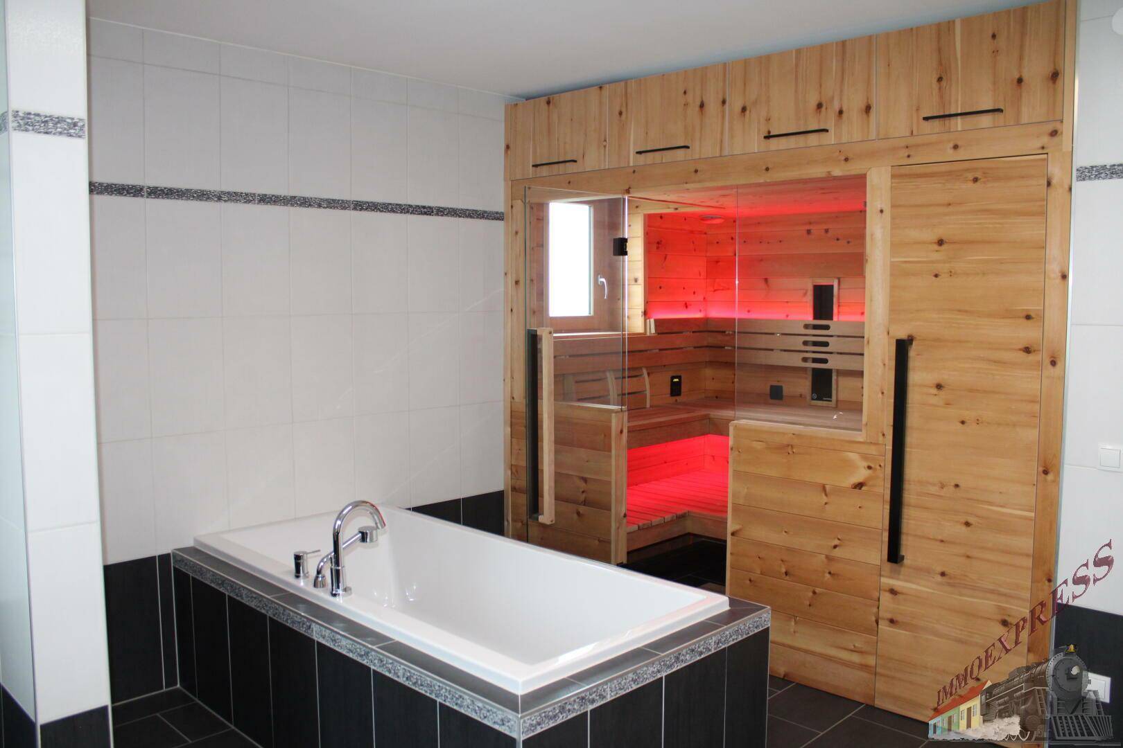 Modernes Badezimmer mit integrierter Sauna und einer Badewanne.