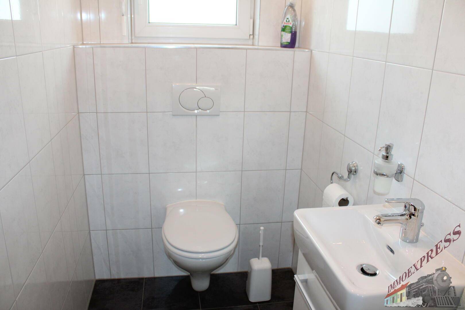Separate Toilette mit Waschbecken und Wand-WC.