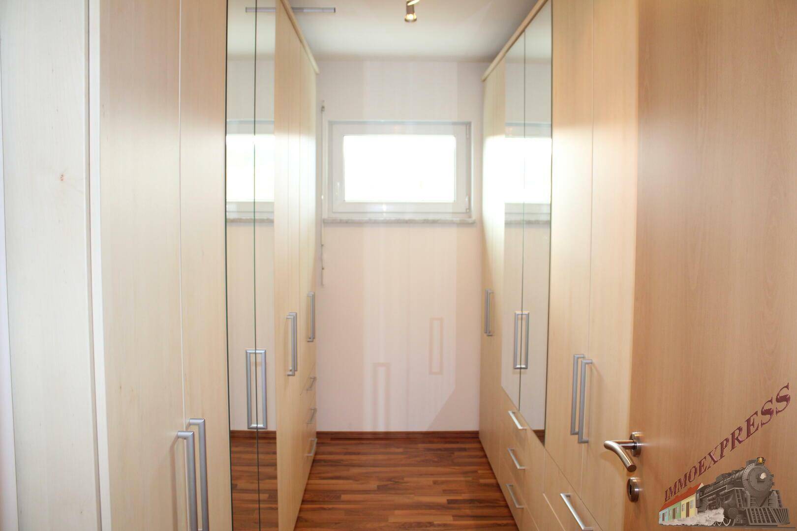 Begehbarer Kleiderschrank mit Spiegeltüren und viel Stauraum.