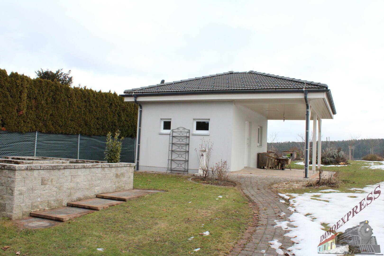 Gartenweg führt am Nebengebäude vorbei zu weiteren Gartenbereichen.