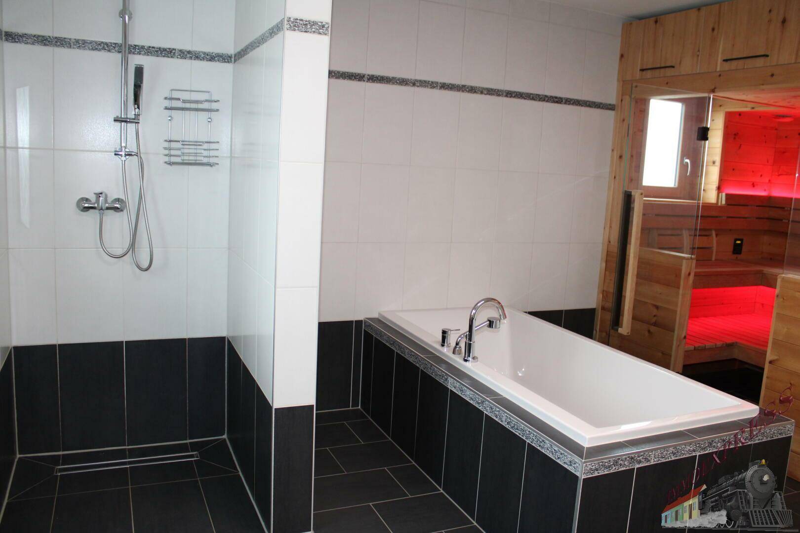 Geräumiges Badezimmer mit Sauna, Badewanne und Duschbereich.