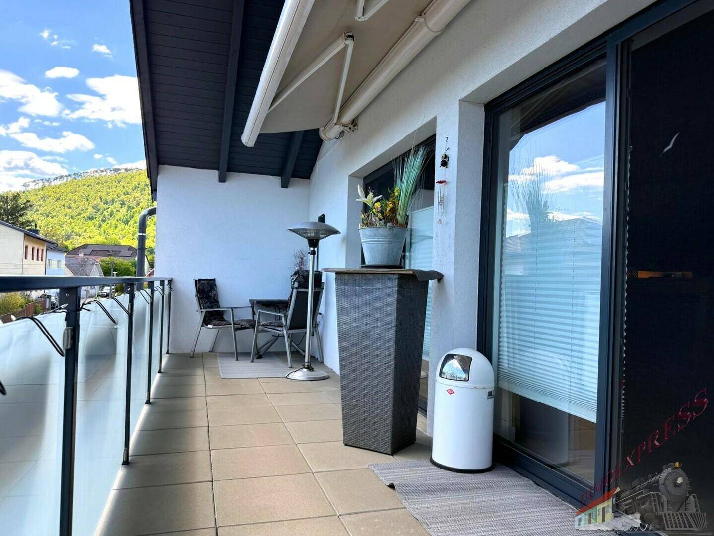 Kleiner Balkon mit Fliesenboden, Markise und Sitzgelegenheiten für entspannte Stunden im Freien.