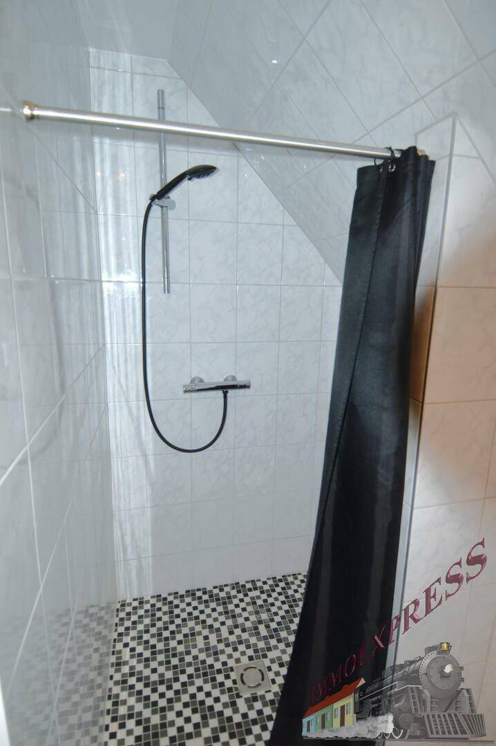Moderne Dusche mit Mosaikfliesen im Duschbereich und schräger Decke.